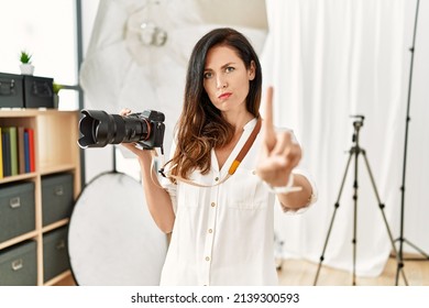 Beautiful Caucasian Woman Working As Photographer At Photography Studio Pointing With Finger Up And Angry Expression, Showing No Gesture 