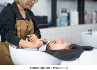 Beautiful Caucasian Women Feel Relax And Comfortable While Getting Hair Wash With Shampoo And Massage. Hair Salon Studio With Hair Stylish, Beauty And Fashion Concept.