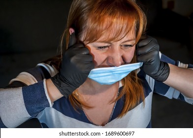 Beautiful Caucasian Young Woman Trying To Rip Off A Protective Face Mask. COVID 19 Novel Coronavirus Disease Outbreak, Tired Of Quarantine, Psychological Problems Concept Image. Covid Dissident