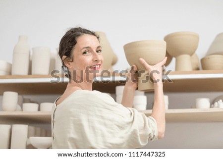 Beautiful ceramist owner looking to the camera while smiling