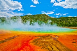 Beautiful Cerulean Geyser Surrounded By Colorful Layers Of Bacteria, Against Cloudy Blue Sky.