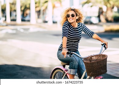 Beautiful And Cheerful Adult Young Woman Enjoy Bike Ride In Sunny Urban Outdoor Leisure Activity In The City - Happy People Portrait - Trendy Female Outside Having Fun
