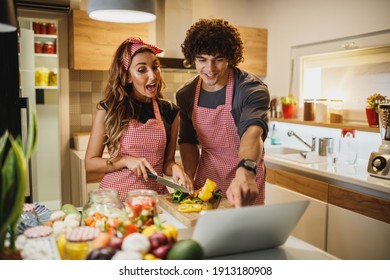 A Beautiful Cheerful Couple Trying Out A New Recipe In The Kitchen Together.