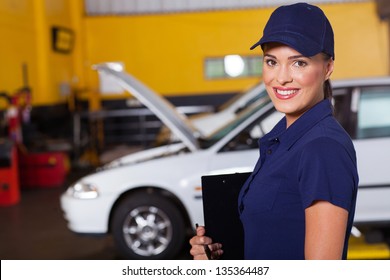 beautiful cheerful female auto garage manager portrait inside workshop - Powered by Shutterstock