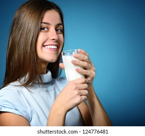 Beautiful Cheerful Teen Girl Drinking Milk Over Blue Background