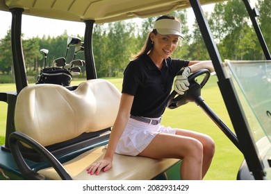 Beautiful cheerful woman sitting in golf cart