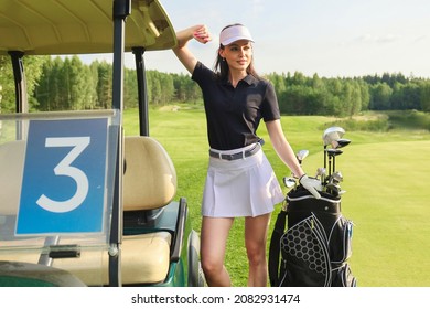 Beautiful cheerful woman standing near in golf cart