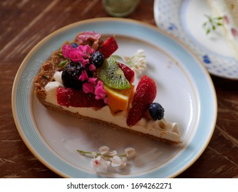 beautiful cheesecake with fresh fruits to offer teatime for peace on a garden background and select focus