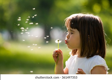 Beautiful child with dandelion flower in spring park. Happy kid having fun outdoors. - Shutterstock ID 361497353