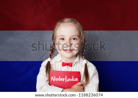 Beautiful child girl smiling and holding book in Netherlandish language school. Learning Dutch