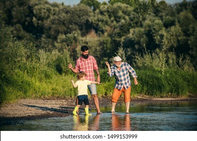 Beautiful Child With Parents Throws A Rock At The River. Skipping Rocks. Three Generation Family