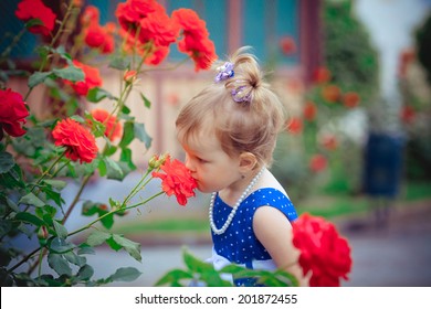 Beautiful Child Smelling Rose Against Spring Flowery Background 