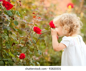 Beautiful Child Smelling Rose Against Spring Flowery Background