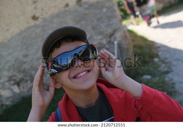 beautiful child with sunglasses smiles in the\
mountains. High quality\
photo