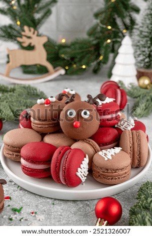 Beautiful Christmas chocolate and raspberry macarons on a plate on a concrete background. Festive dessert. Top view, copy space