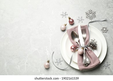 Beautiful Christmas Table Setting And Festive Decor On Light Grey Marble Background, Flat Lay. Space For Text