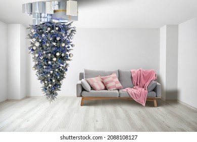 Beautiful Christmas tree with gift boxes hanging on ceiling in room