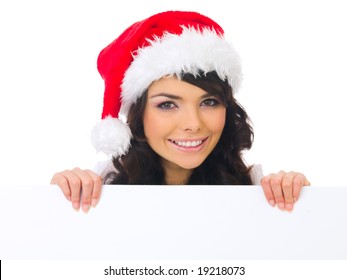 Beautiful christmas woman in santa hat holding empty board - Powered by Shutterstock