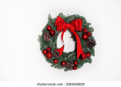 Beautiful christmas wreath of fir branches with red bow and red balls on white wall. Horizontal. - Powered by Shutterstock