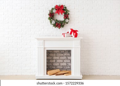 Beautiful Christmas Wreath Hanging On Wall Near Fireplace With Gift Boxes