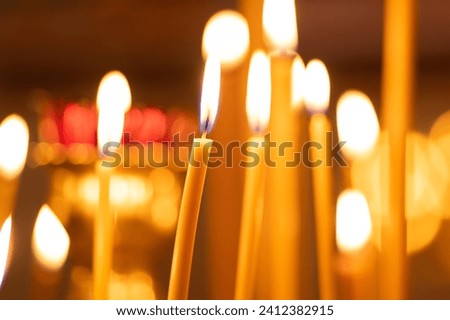 Beautiful church burning candles close-up. Burning thin church candles. Candles in the church.