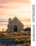 Beautiful Church of the good shepherd with female tourist enjoying in the morning at Lake Tekapo, New Zealand