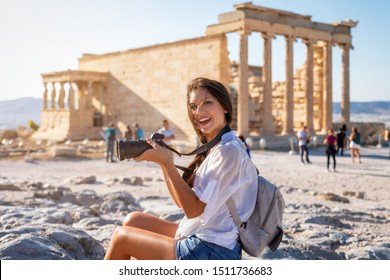 A beautiful city tourist woman with a camera in her hand explores the ancient Partenon temple of the Acropolis of Athens, Greece - Powered by Shutterstock