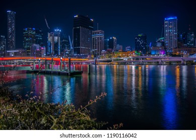 Beautiful cityscape with highrise towers in neon lights reflecting in calm city river water in night time - Powered by Shutterstock