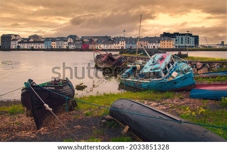 Beautiful cityscape scenery with old colorful wooden boats on the shore of Corrib River at Galway City in Ireland 