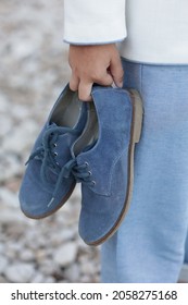 Beautiful classic men's shoes held by the hand of a child - Shutterstock ID 2058275168