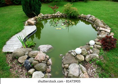 Beautiful classical design garden fish pond in a well cared backyard gardening background