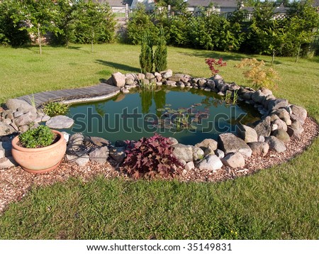 Beautiful classical garden fish pond surrounded by grass