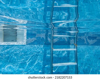 Beautiful Clean Blue Water And Decorative Pool Liner With Ladder And Skimmer Pool Equipment Underwater Camera Captures Tranquil Scene With Reflection. Copy Space, No People, Shot Outdoors In Natural