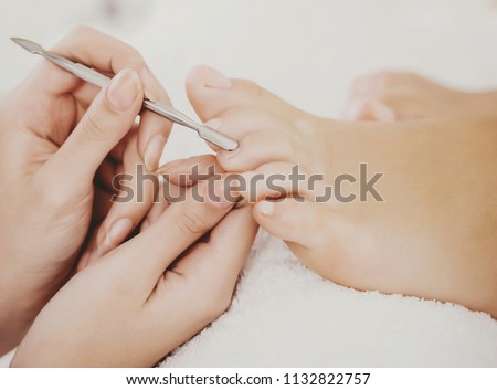 Beautiful Clean Female Fingers in Spa Composition. Pedicure Process in Beauty Salon. Cuticle Removal on Toes. Female Pedicure Closeup. Process of Professional Pedicures. Concept of Beauty and Health.