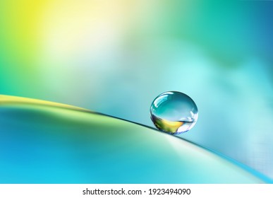 Beautiful Clean Transparent Bright Drop Of Water On Smooth Surface In Blue And Yellow Colors, Macro. Creative Image Of Beauty Of Environment And Nature.