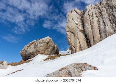 Beautiful clear sky and sunny weather on the snowy mountain during spring time. Rock formations rising from the snow on the hike near Babele and Sfinxul, Romania
