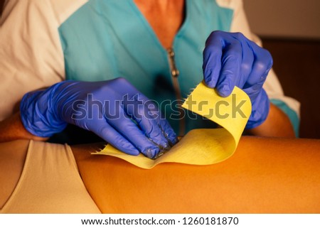 Beautiful client and dermologist cosmetologist woman having a sugaring depilation bikini area beauty treatment in the spa salon