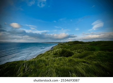 A beautiful cliff that provides a stunning view overlooking the vast ocean with a lush grassy hill in the foreground, enhancing the scene - Powered by Shutterstock