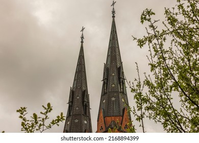 Beautiful close up view of top towers of Uppsala Cathedral Church on pale sky background. Sweden.