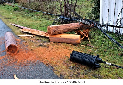 A Beautiful Closeup View Of Windstorm Damage Of Communication Infrastructure With Pieces Of Wooden Pole And Wiring Laying Alongside Road 