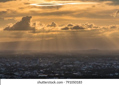 Beautiful clouds in the sky with light through the clouds over the city at sunset.