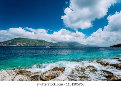 Beautiful cloudscape near Fiskardo, Kefalonia, Ionian islands, Greece. Crystal clear transparent blue turquoise teal Mediterranean sea water in Fiskardo town.