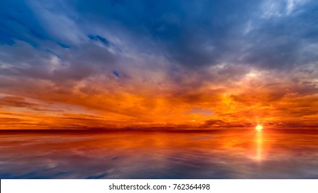 Beautiful cloudscape and sunset breaking through cloud over lake reflection. god rays, also called crepuscular rays, streaming through gaps in clouds.