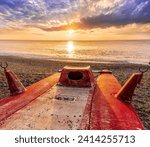 beautiful cloudy morning landscape with diving mask on a red old boat on foreground, sand beach, blue sea with surf and waves and cloudy sunset or sunrise on background