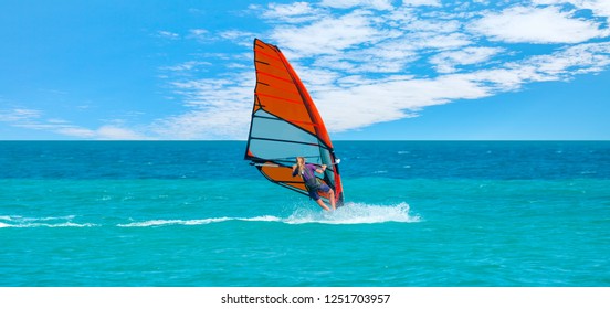 Beautiful cloudy sky with Windsurfer Surfing The Wind On Waves In Alacati - Cesme, Turkey