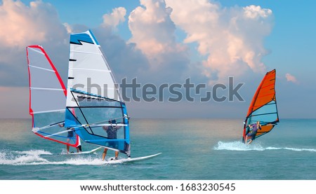 Beautiful cloudy sky with Windsurfer Surfing The Wind On Waves In Alacati - Cesme, Turkey 