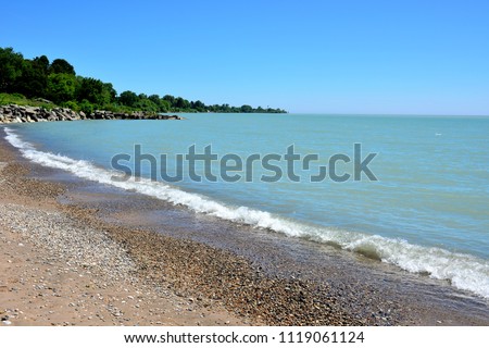 Beautiful coast line beach with a wave ripple along the entire shoreline on a sunny day.