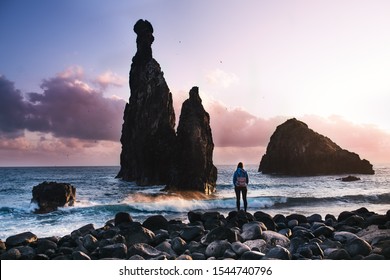 Beautiful coast view during a sunset with young man standing against rocks. Ilheus da Ribeira da Janela - Madeira, Portugal. Madeira, the Portuguese island of eternal spring. - Shutterstock ID 1544740796