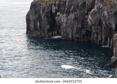 A beautiful coastal area in eastern part of Japan. A clear blue sky and an orange sunrise reflects on the sea water. A big rock formation in the coast line. Island from the distance. - Powered by Shutterstock