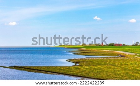 Beautiful coastal and dike landscape panorama with water stones fields and forest at Imsum dyke dike in Geestland Cuxhaven Lower Saxony Germany.